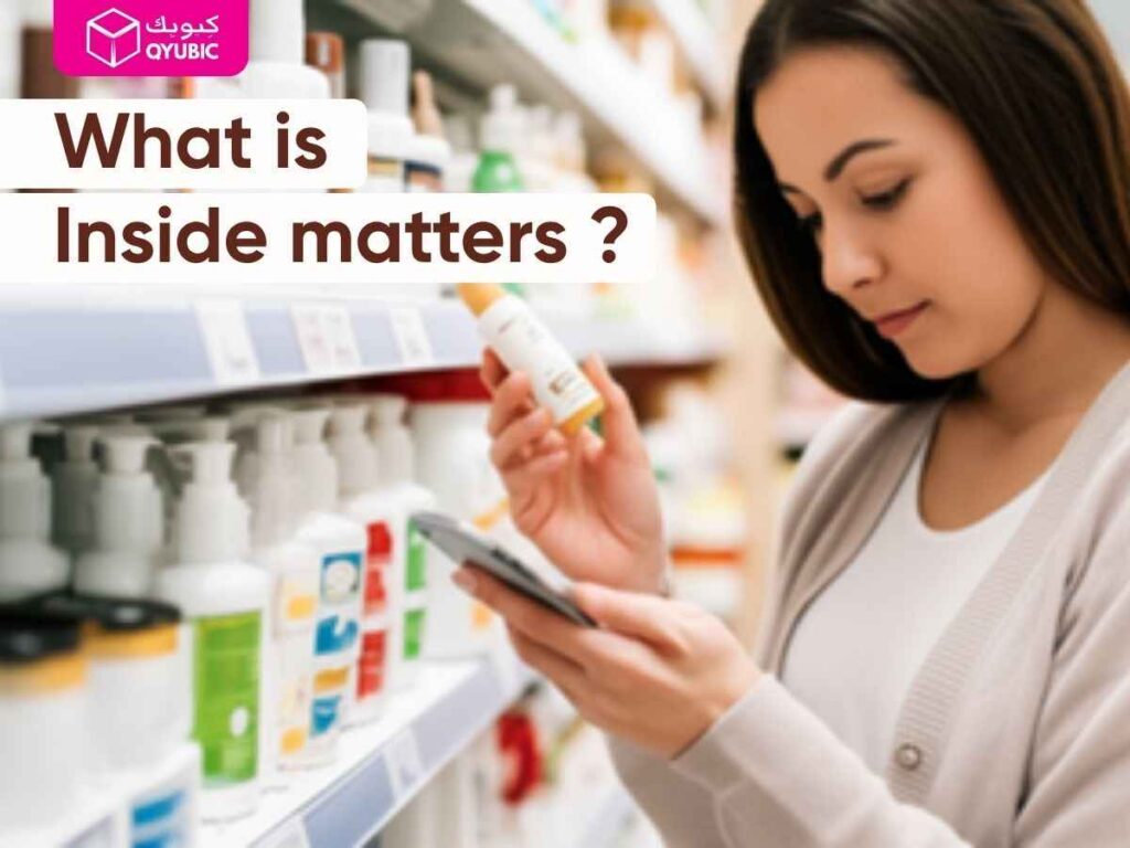 Young mother reading a lotion ingredient label in a store aisle, holding a baby lotion bottle and smartphone, with the overlay text ‘What Is Inside Matters?’ and QYUBIC logo.