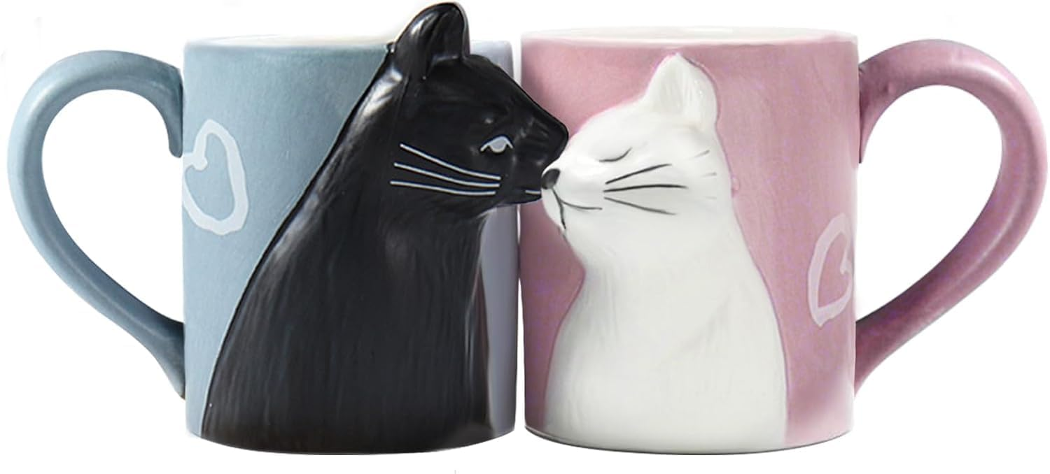 Set of two ceramic mugs featuring a romantic design with a black cat on a blue mug and a white cat on a pink mug, their noses touching to form an adorable kissing pose, perfect for couples or cat lovers.