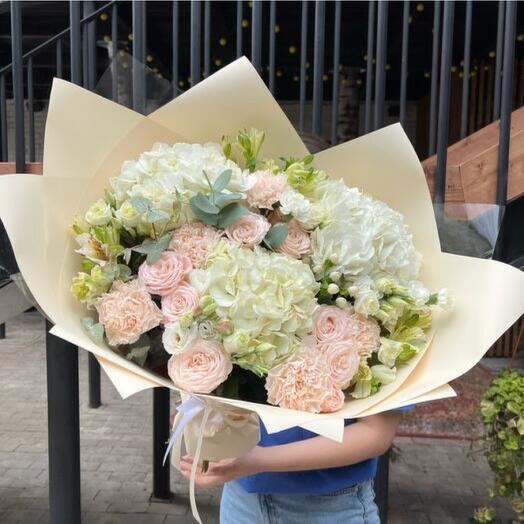 Beautiful bouquet with a blend of white and pastel pink roses, hydrangeas, and greenery, offering a timeless selection of the best anniversary flowers.