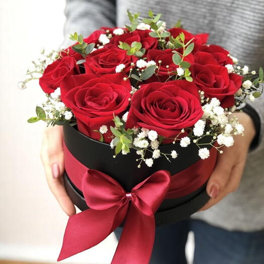 Beautiful round bouquet of red roses arranged in a black box with a satin ribbon. A luxurious and romantic gift, perfect for celebrating anniversaries or special moments with loved ones.